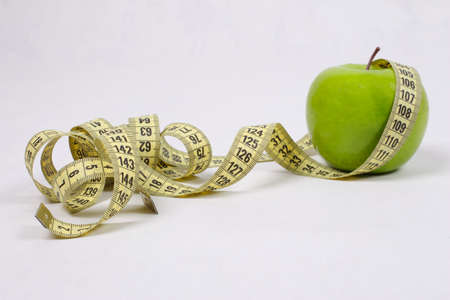 green apple and centimeter on a white backgroundの写真素材