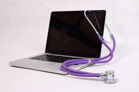 Medical stethoscope and laptop on a white backgroundの写真素材