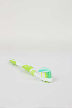 green toothbrush with toothpaste on a white backgroundの写真素材