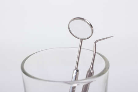 dental instruments in a glass on a white backgroundの写真素材