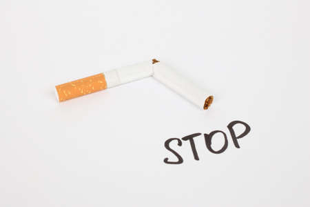 cigarette broken in half on a white backgroundの写真素材