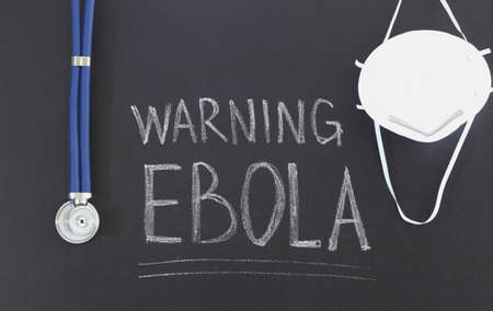 stethoscope and mask with an inscription in chalk on the blackboardの写真素材