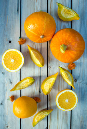The concept of the collection of sliced pumpkin pieces to share, oranges and carrots. Autumn sliced pumpkin pieces to share, oranges and carrots of on a wooden table. Selective Focusの写真素材