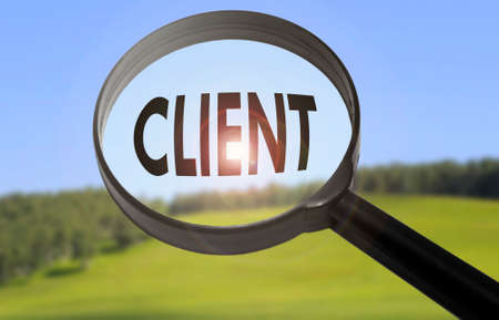 Magnifying glass with the word client on blurred nature background. Searching client conceptの写真素材