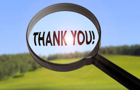 Magnifying glass with the word thank you on blurred nature background. Searching thank you conceptの写真素材