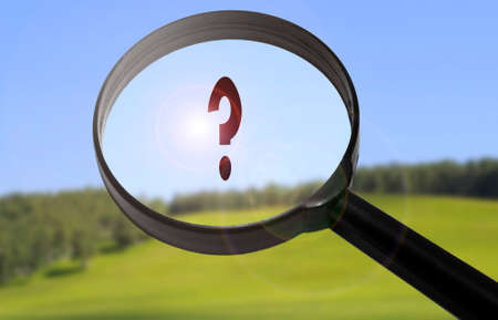 Magnifying glass with the word question on blurred nature background. Searching question conceptの写真素材