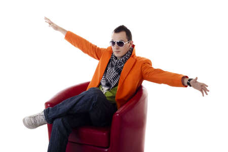 Stylish guy with glasses sitting on a red chair