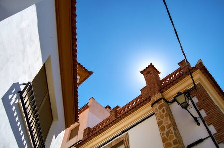 Sun hiding behind the chimney in the roof of a typical Andalusian house.の写真素材