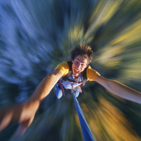 Selfie shot during bungee jumping. Adventure holiday. Ropejumping man having fun, extreme sports concept, embracing freedom, excitement and adrenaline rush.の素材