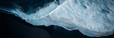 Stunning aerial perspective of ocean waves with white foam crashing on the black sand beach, showcasing the raw beauty of Icelandic natureの写真素材