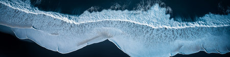 Stunning aerial perspective of ocean waves with white foam crashing on the black sand beach, showcasing the raw beauty of Icelandic natureの写真素材