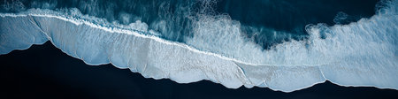 Stunning aerial perspective of ocean waves with white foam crashing on the black sand beach,...