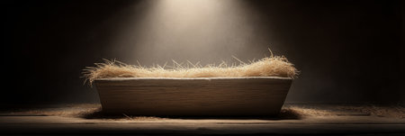Empty wooden manger with straw receiving warm light, symbolizing birth and new beginnings. Wooden...