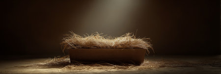 Empty wooden manger with straw receiving warm light, symbolizing birth and new beginnings. Wooden...