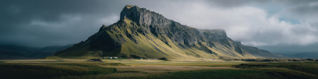 Lush green Icelandic valley with rugged mountains under a cloudy sky. Icelandic valley with...