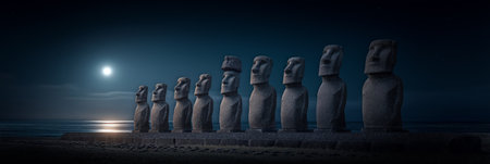 Ancient Moai statues standing by the ocean under a night sky with bright moonlight. Moai statues on Easter Island watching rising moonlightの写真素材