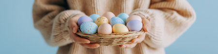 Person holding a small basket filled with colorful speckled Easter eggs in hands. Easter background. Person holding woven basket with pastel Easter eggsの写真素材
