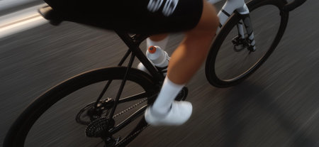 Cyclist riding bicycle with motion blur, emphasizing speed, fitness, and movement. Cyclist...