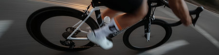 Cyclist riding bicycle with motion blur, emphasizing speed, fitness, and movement. Cyclist...