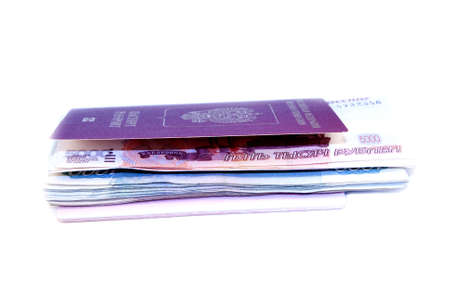 Pile of money invested in their passport on a white backgroundの写真素材