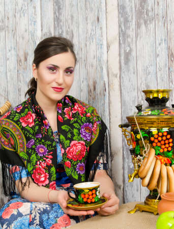 Beautiful brunette sitting at the samovar with bagelsの写真素材