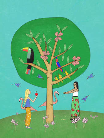 Girls feeding tropical birds in the wildの写真素材