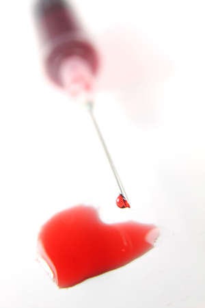 Syringe with heart shaped blood dropsの写真素材