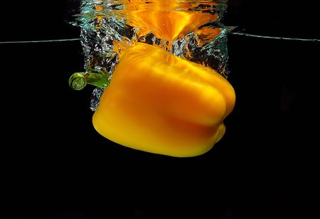 Yellow pepper falling into waterの写真素材