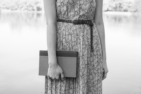 Young woman reading bible in natural parkの写真素材