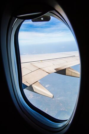 Clouds and sky as seen through window of an aircraftの写真素材
