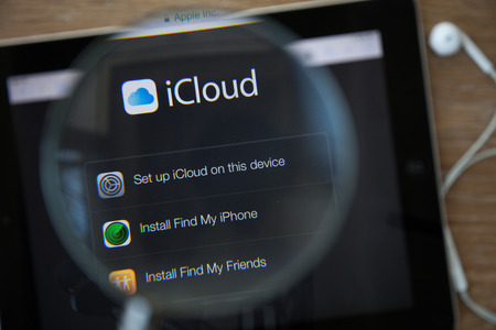CHIANGMAI, THAILAND - February 26, 2015: Photo of Icloud homepage on a ipad monitor screen through a magnifying glass.のeditorial素材