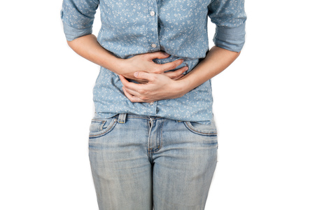 Young beautiful woman is having stomach ache. Isolated on white.の写真素材