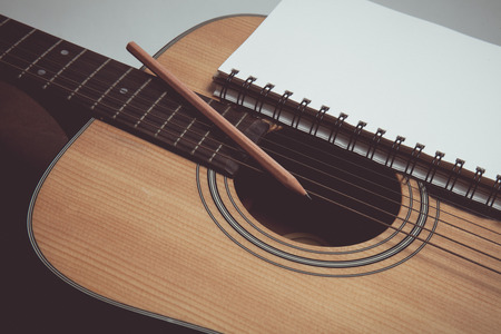 Pencil and paper on guitar in vintage styleの写真素材