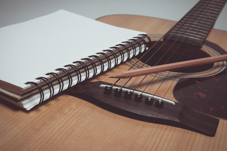 Pencil and paper on guitar in vintage styleの写真素材