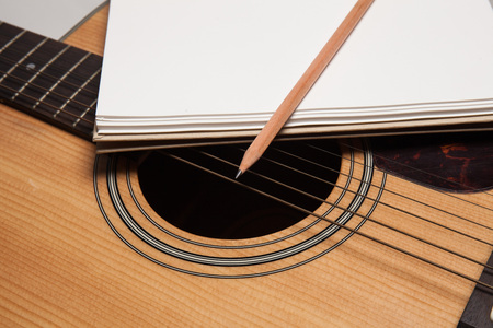 Notebook and pencil on guitarの写真素材