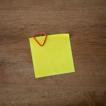 Blank paper card with heart clip on wood backgroundの写真素材