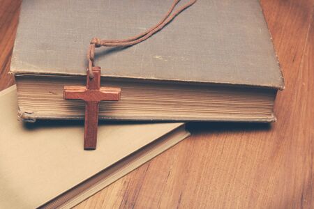 Vintage tone of wooden Christian cross necklace on holy Bible with copy spaceの写真素材
