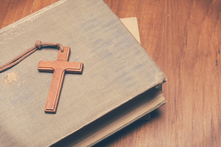 Vintage tone of wooden Christian cross necklace on holy Bible with copy spaceの写真素材
