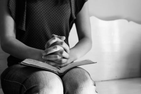 Vintage tone of woman hands on bible. she is reading and praying over bibleの写真素材