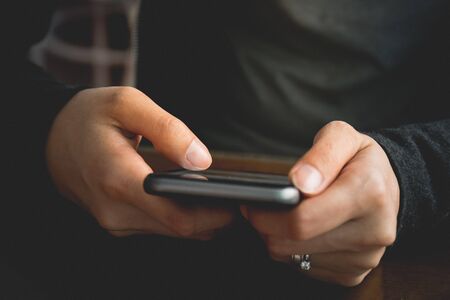 Hipster using a touch screen smart phone hands close up, vintage colors
