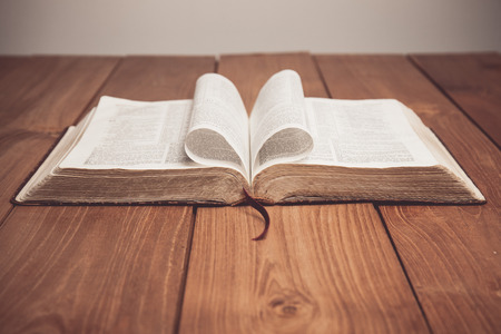 Vintage tone of Bible on table with pages folded into heart shapeの写真素材