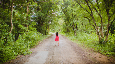 woman on a summit with upraised arms in the forest tunnel, Praise for GOD.の写真素材