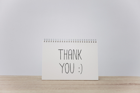 THANK YOU with mock up of blank paper on tableの写真素材