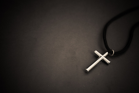 metal cross on black table. religion concept.の写真素材