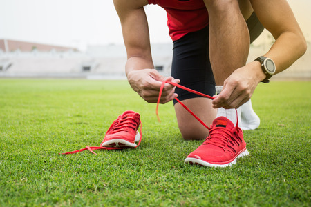 Man tying running shoes and prepare to runの写真素材