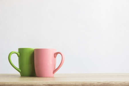 A colorful coffee cup on a wooden tableの写真素材
