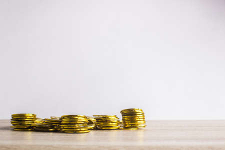 Many stacks of coins on table against light background