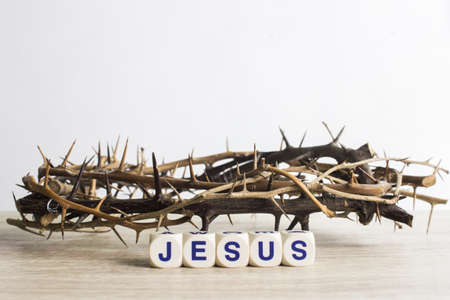 A word "Jesus" with thorn crown on a wooden table.の写真素材