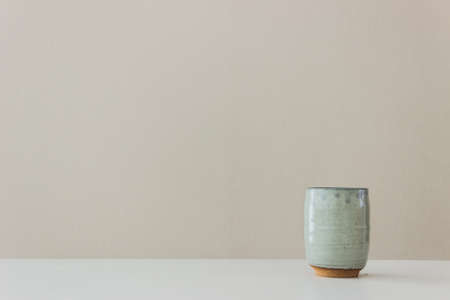A coffee mug on table over the light wall.の写真素材