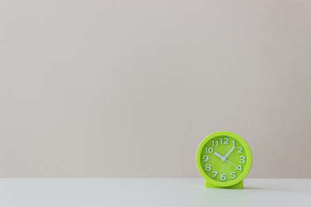 A green clock on table over the light background.の写真素材